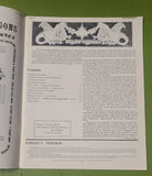 Open book with text and illustrations on a green surface